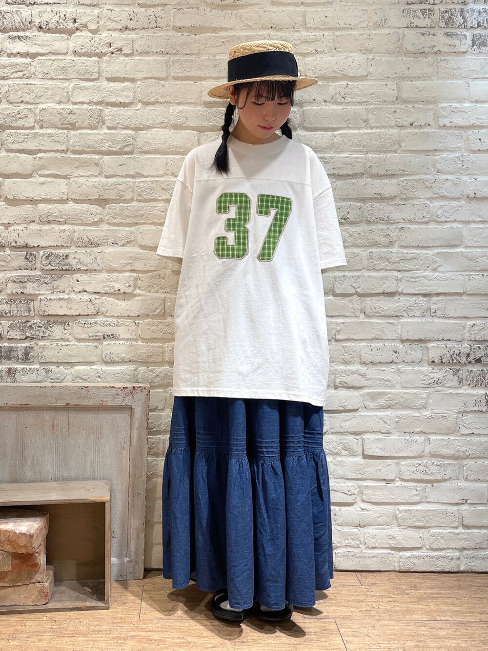 ブラウン系のチュニック、ホワイト系のTシャツ/カットソー、ブルー系のスカートを着用したレディースの夏コーディネートの4枚目の写真