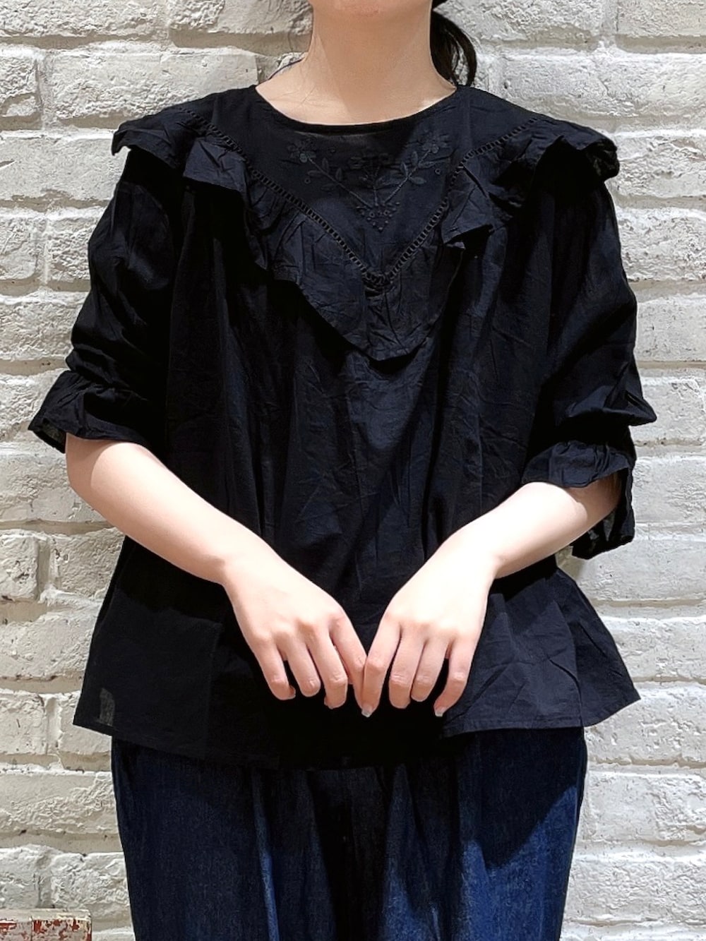 ブラック系のシャツ/ブラウス、ブルー系のデニムパンツ、ブラウン系のハットを着用したレディースの夏コーディネートの2枚目の写真