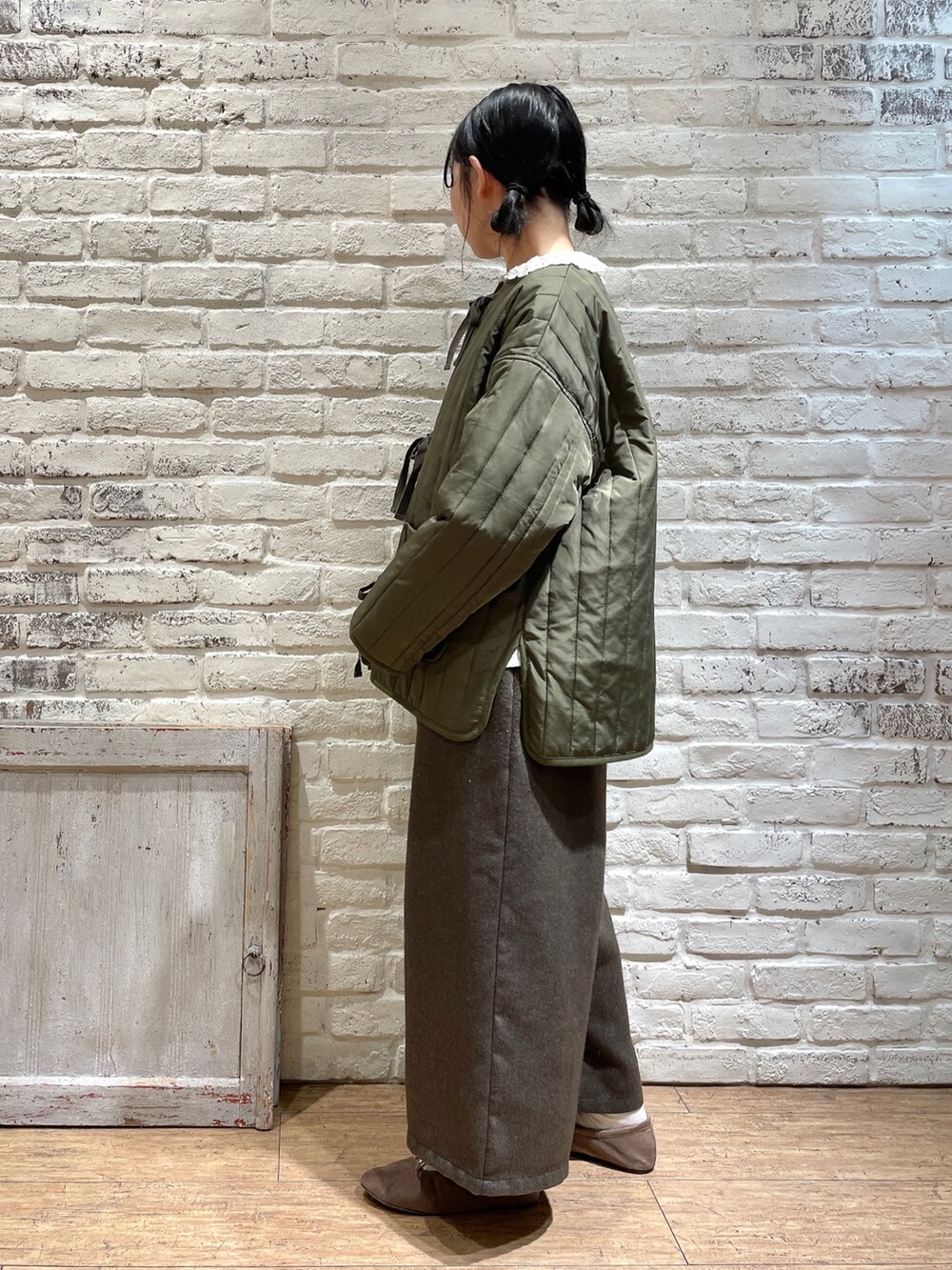 ホワイト系のシャツ/ブラウス、グリーン系のノーカラージャケット、ブラック系のパンツを着用したレディースの冬コーディネートの2枚目の写真