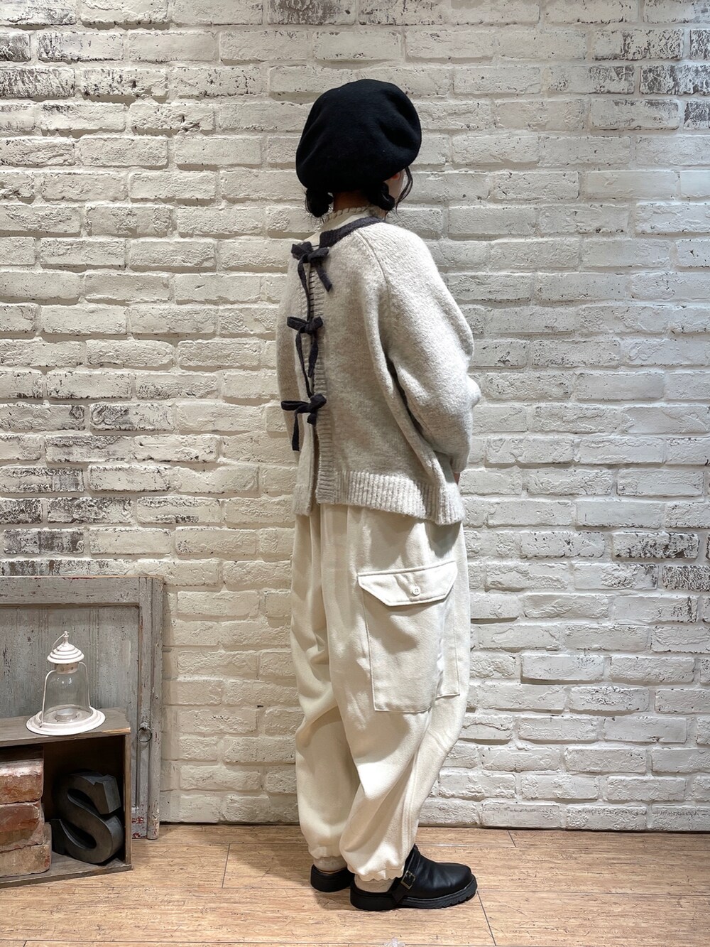 ベージュ系のカーディガン/ボレロ、ホワイト系のニット/セーター、ベージュ系のカーゴパンツを着用したレディースの秋コーディネートの2枚目の写真