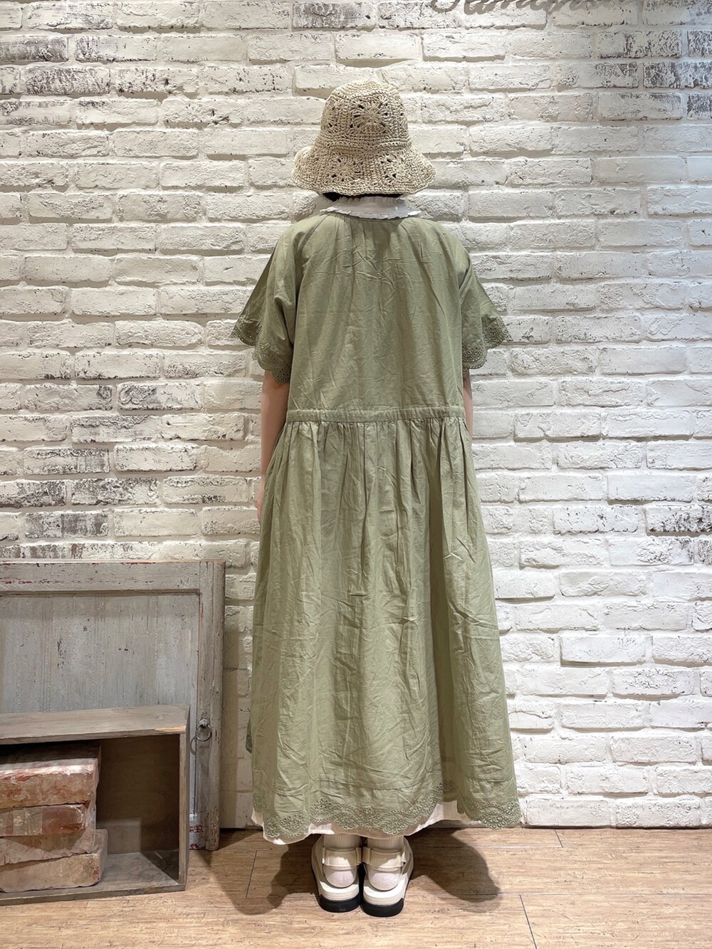 ベージュ系のトートバッグ、ホワイト系のサンダル、グリーン系のワンピースを着用したレディースの夏コーディネートの3枚目の写真