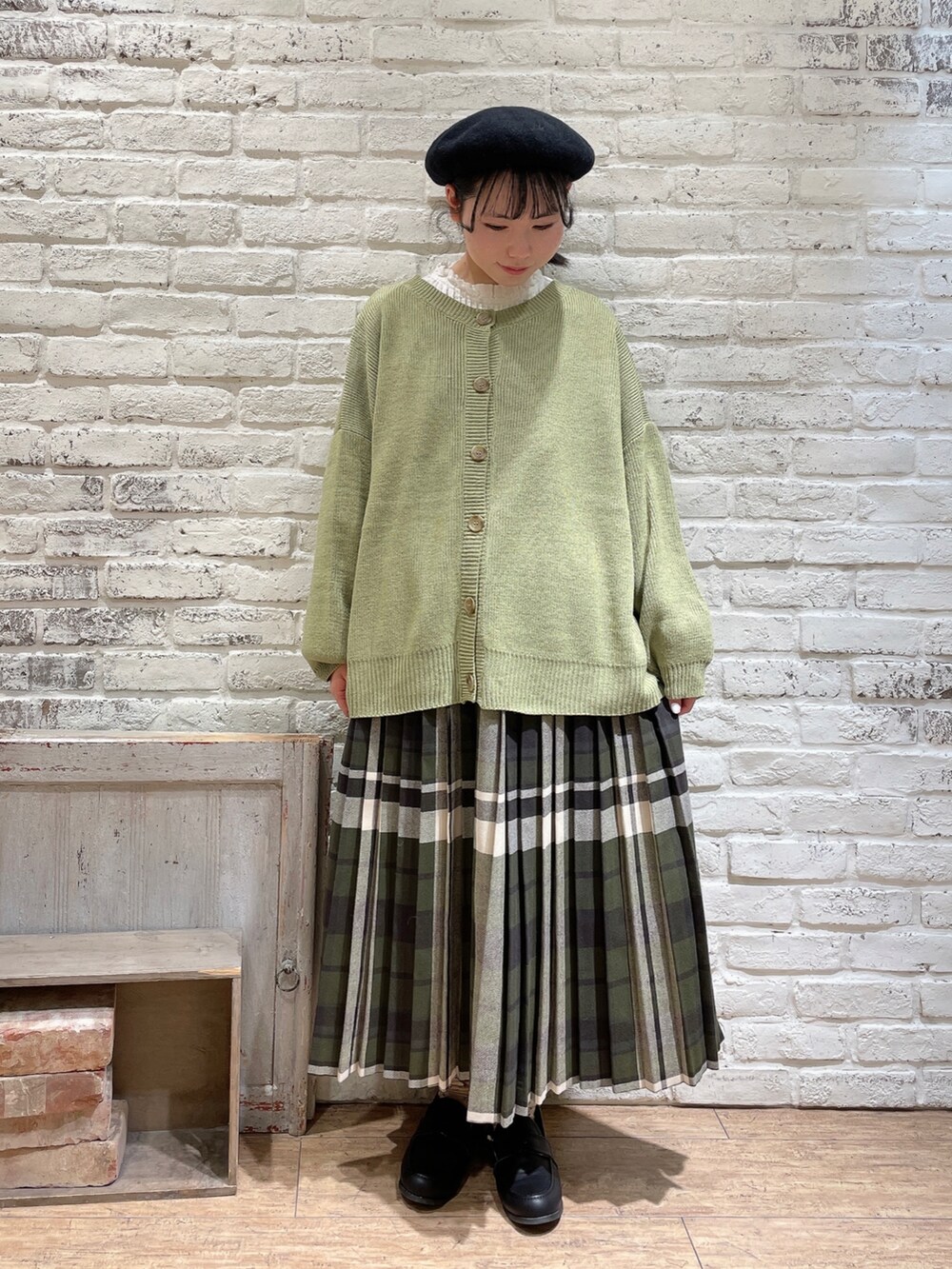 ホワイト系のシャツ/ブラウス、グリーン系のニット/セーター、ブルー系のスカートを着用したレディースの冬コーディネートの4枚目の写真