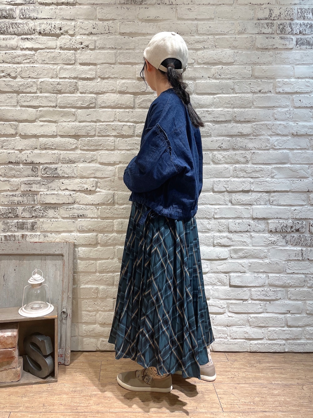 ブルー系のノーカラージャケット、ホワイト系のニット/セーター、グリーン系のスカートを着用したレディースの秋コーディネートの2枚目の写真