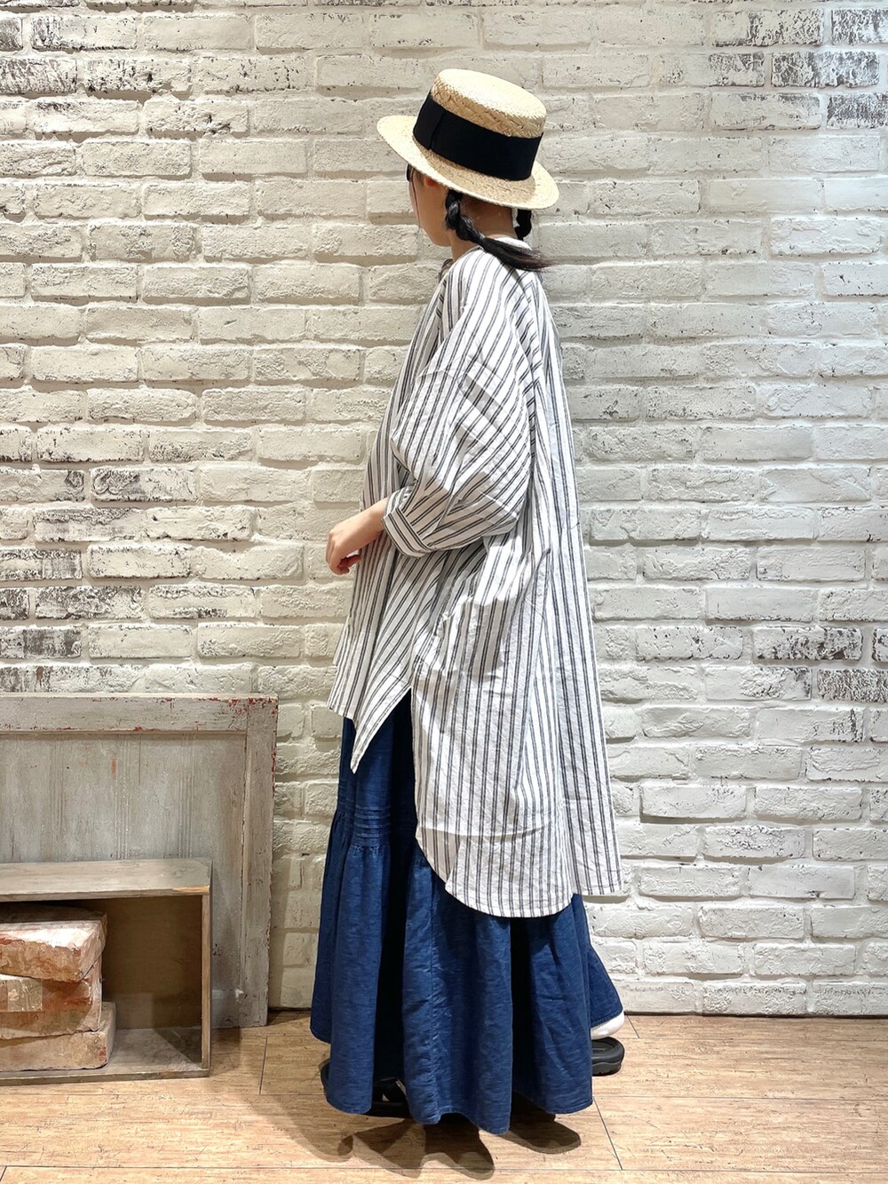 ブラウン系のチュニック、ホワイト系のTシャツ/カットソー、ブルー系のスカートを着用したレディースの夏コーディネートの2枚目の写真