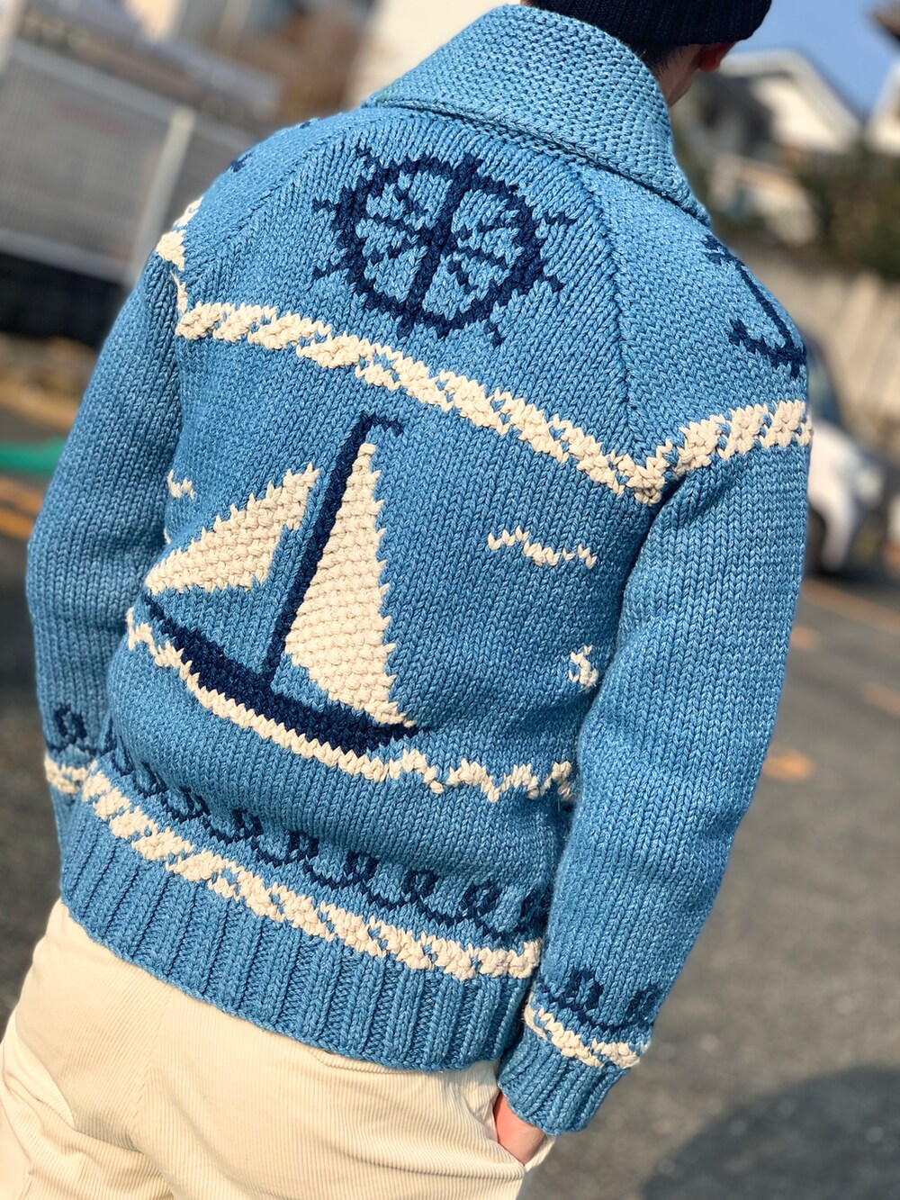 ホワイト系のニット/セーター、ブルー系のカーディガン/ボレロ、ベージュ系のその他パンツを着用したメンズの春コーディネートの4枚目の写真