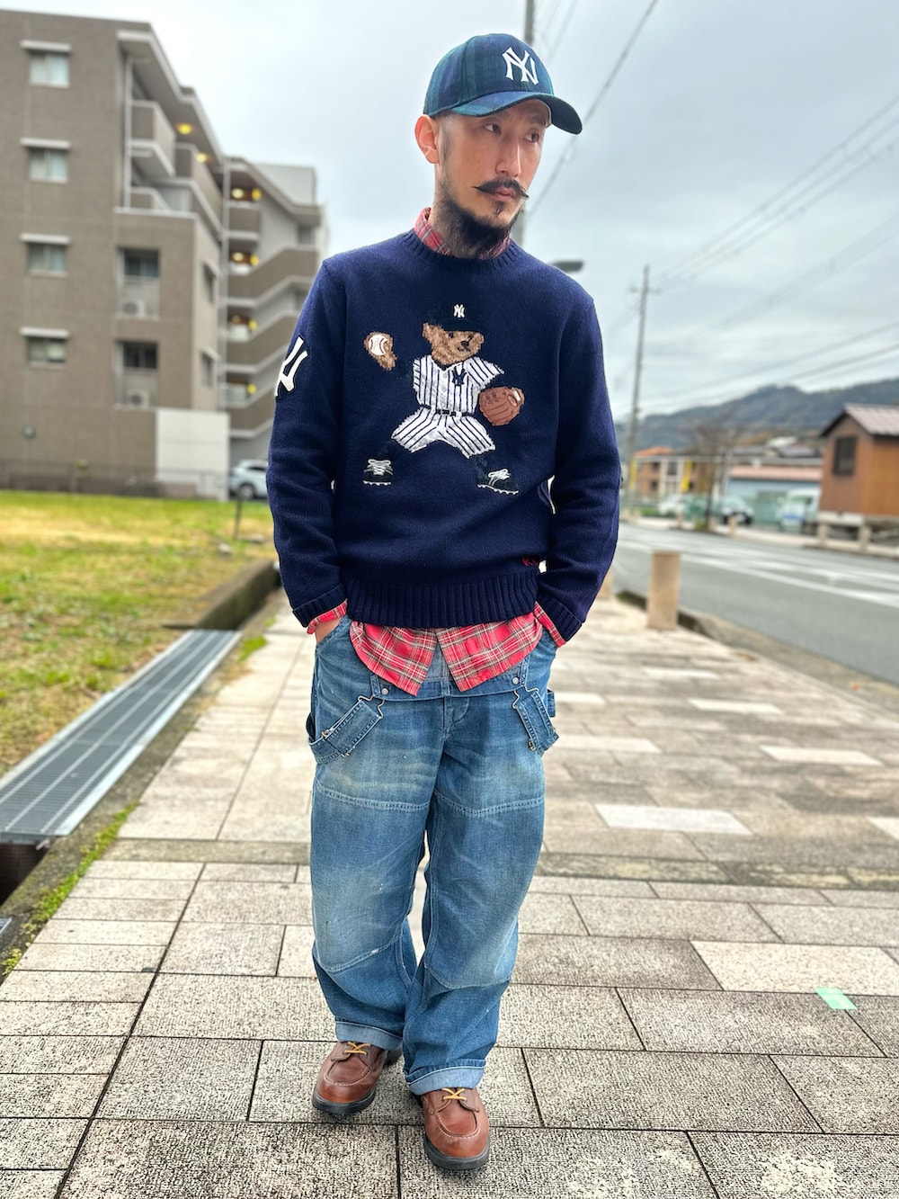 レッド系のシャツ/ブラウス、ブルー系のニット/セーター、ブルー系のサロペット/オーバーオールを着用したメンズの秋コーディネートの2枚目の写真