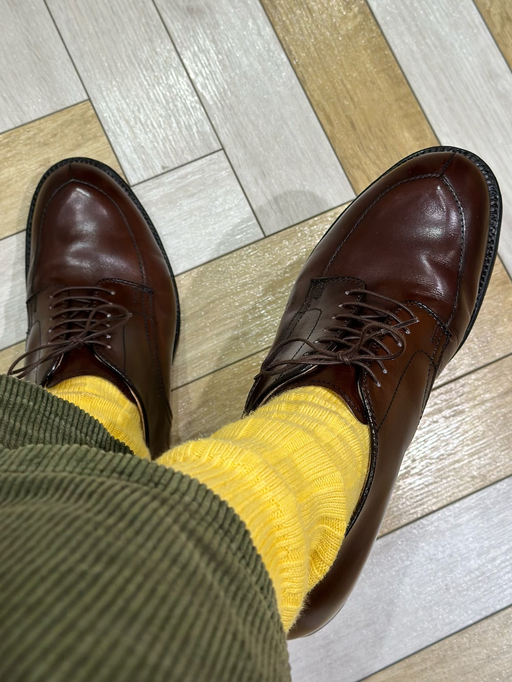 ブルー系のシャツ/ブラウス、イエロー系のニット/セーター、その他のその他アウターを着用したメンズの冬コーディネートの4枚目の写真