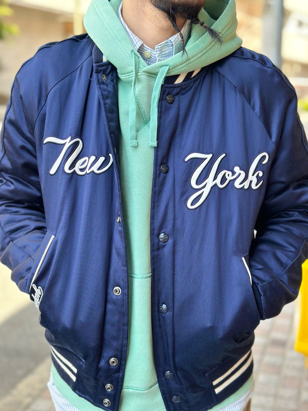 ブルー系のシャツ/ブラウス、グリーン系のパーカー、ブルー系のスタジャンを着用したメンズの春コーディネートの4枚目の写真