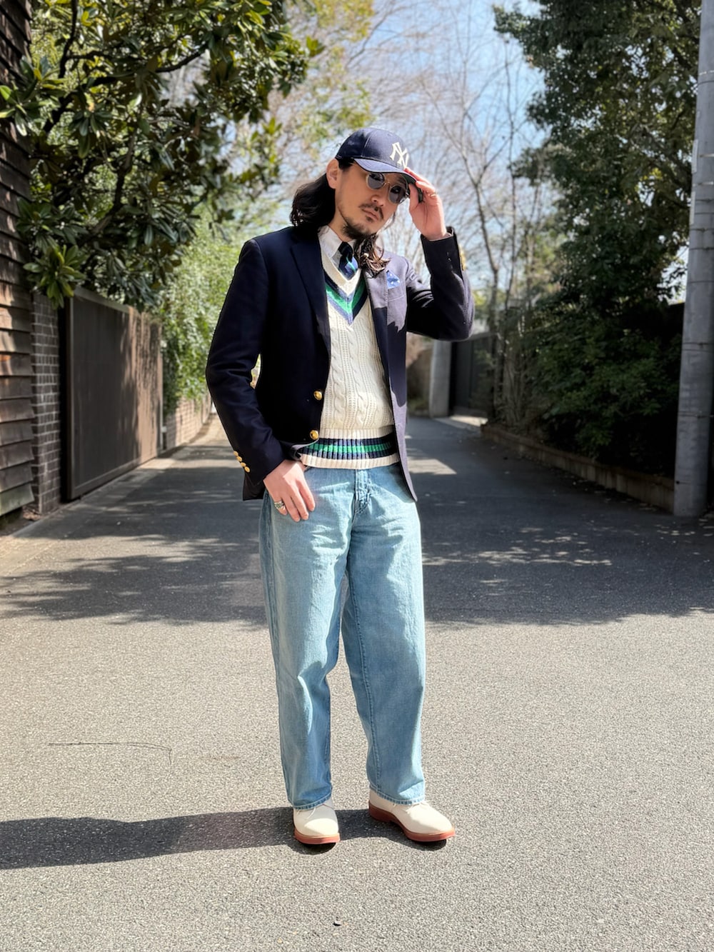 グリーン系のネクタイ、ブルー系のテーラードジャケット、ホワイト系のベストを着用したメンズの春コーディネートの2枚目の写真