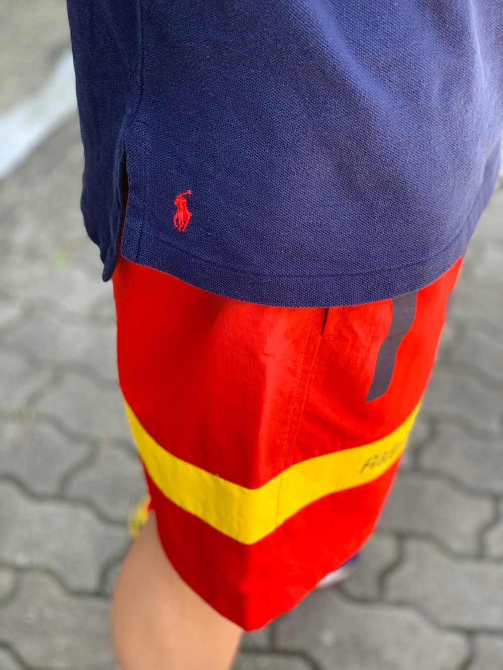 ブルー系のポロシャツ、レッド系のその他パンツ、その他のスニーカーを着用したメンズの夏コーディネートの4枚目の写真