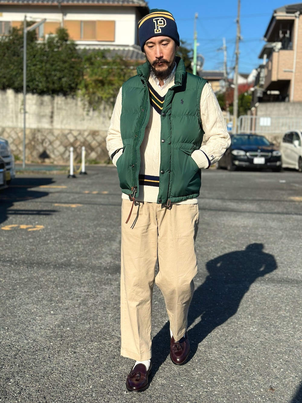 ホワイト系のシャツ/ブラウス、ホワイト系のニット/セーター、グリーン系のダウンベストを着用したメンズの秋コーディネートの2枚目の写真