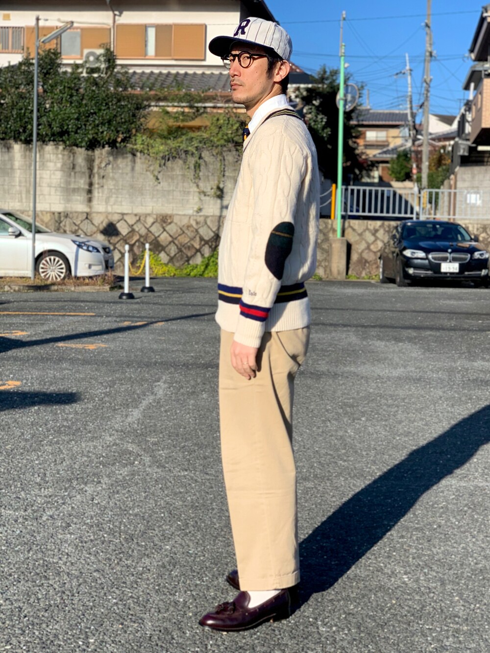 ブルー系のシャツ/ブラウス、イエロー系のネクタイ、ホワイト系のニット/セーターを着用したメンズの冬コーディネートの2枚目の写真