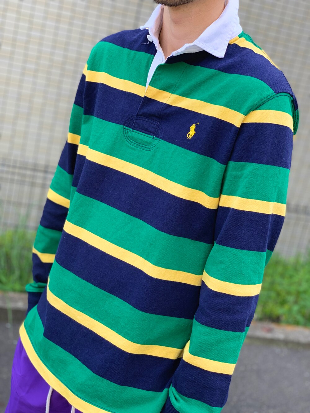 グリーン系のポロシャツ、パープル系のその他パンツ、レッド系のモカシン/デッキシューズを着用したメンズの春コーディネートの2枚目の写真