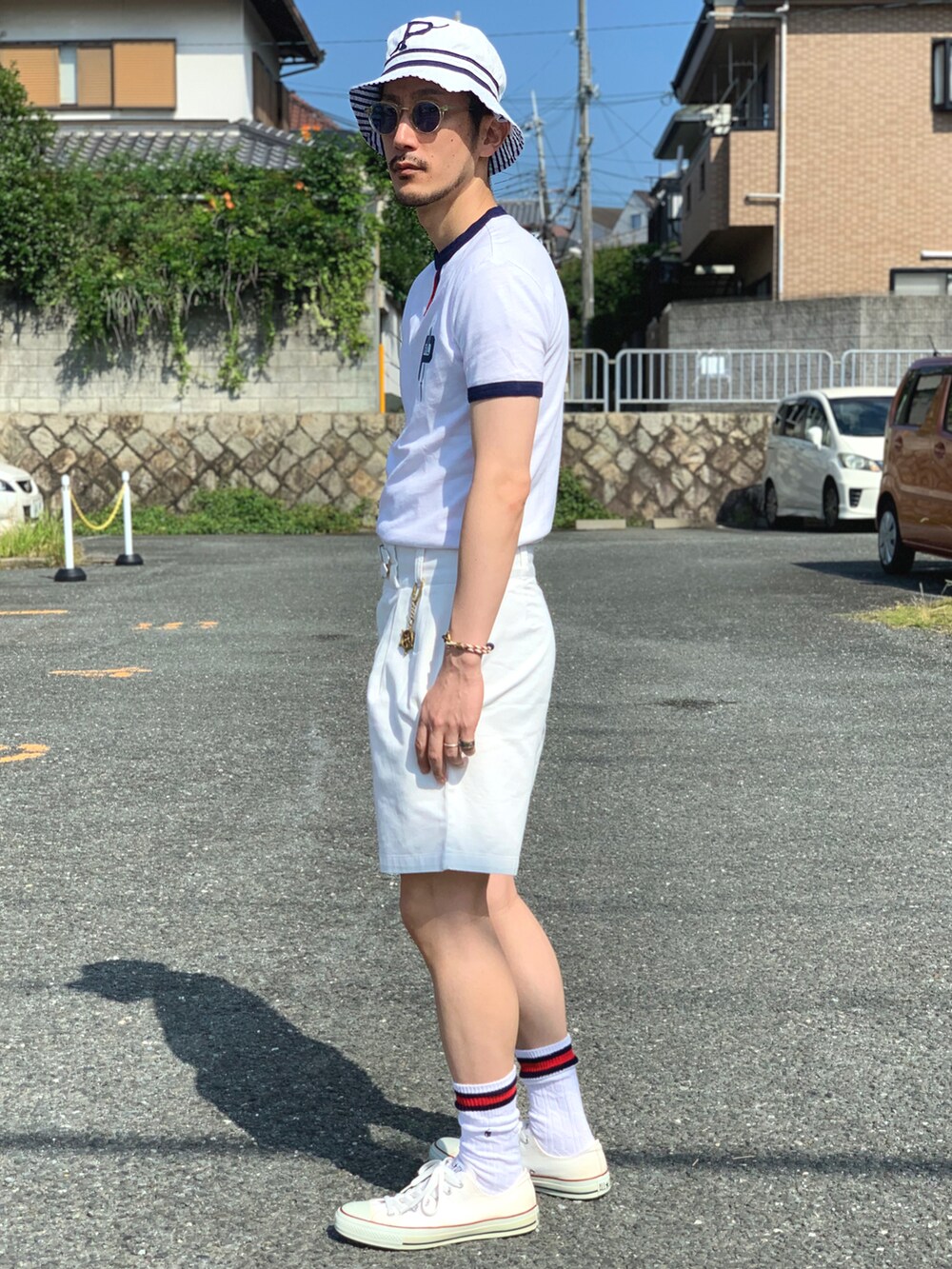 ホワイト系のTシャツ/カットソー、ホワイト系のチノパンツ、ホワイト系のスニーカーを着用したメンズの夏コーディネートの2枚目の写真