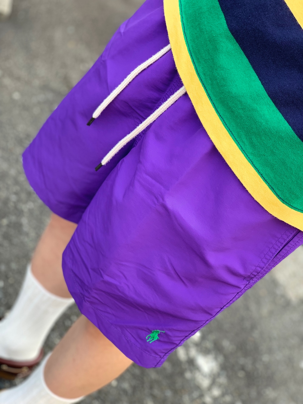 グリーン系のポロシャツ、パープル系のその他パンツ、レッド系のモカシン/デッキシューズを着用したメンズの春コーディネートの3枚目の写真