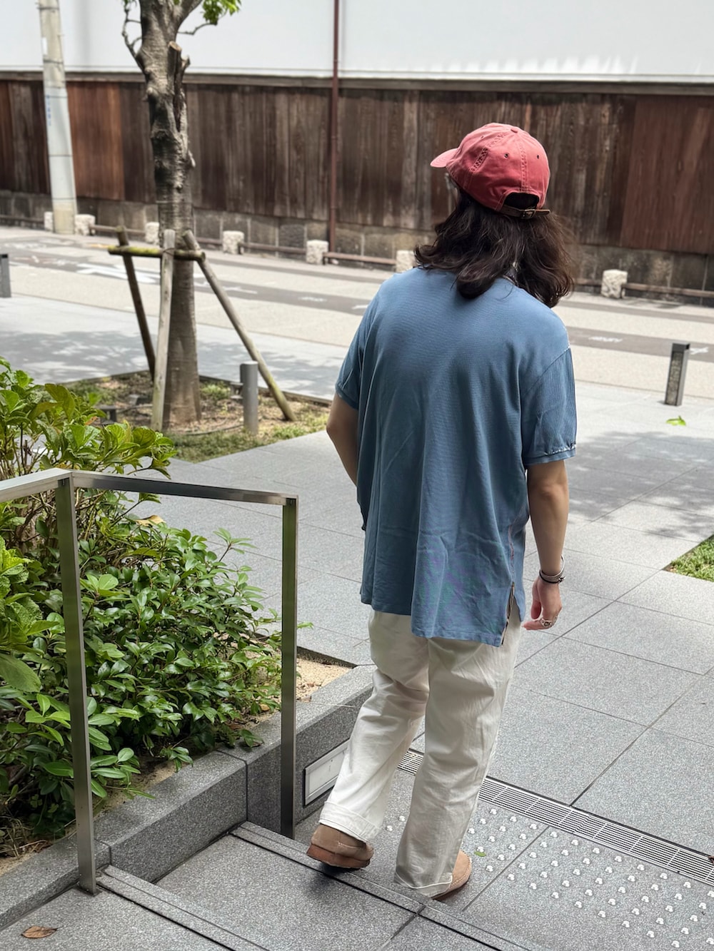 ブルー系のポロシャツ、ホワイト系のチノパンツ、ベージュ系のブーツを着用したメンズの夏コーディネートの3枚目の写真