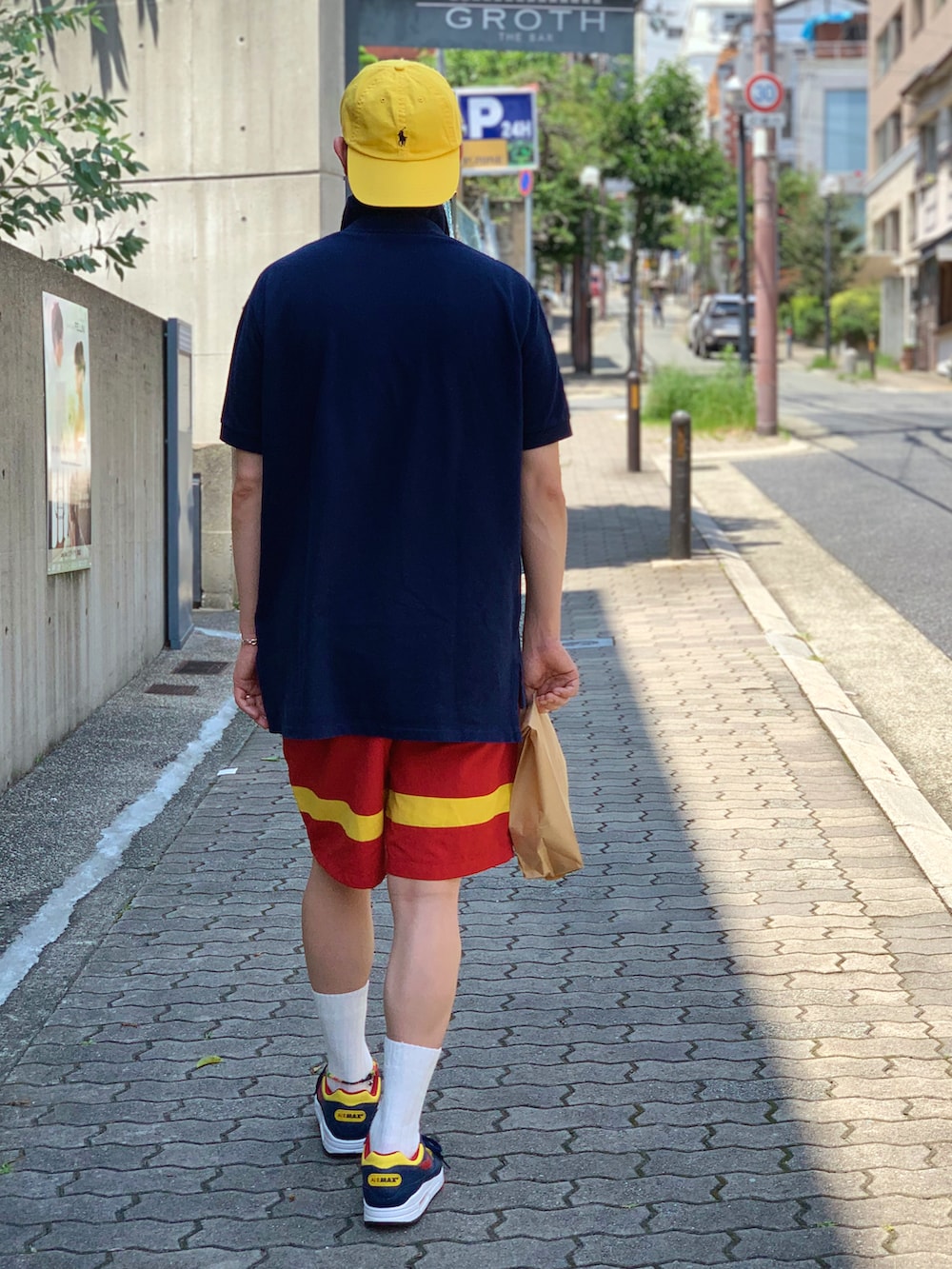 ブルー系のポロシャツ、レッド系のその他パンツ、その他のスニーカーを着用したメンズの夏コーディネートの3枚目の写真