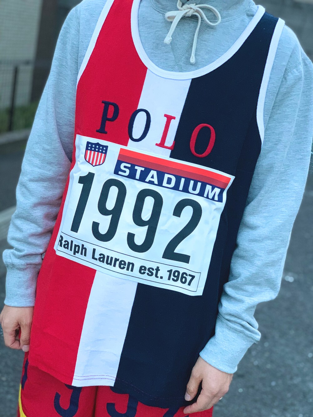 グレー系のパーカー、ホワイト系のタンクトップ、レッド系のその他パンツを着用したメンズの春コーディネートの4枚目の写真