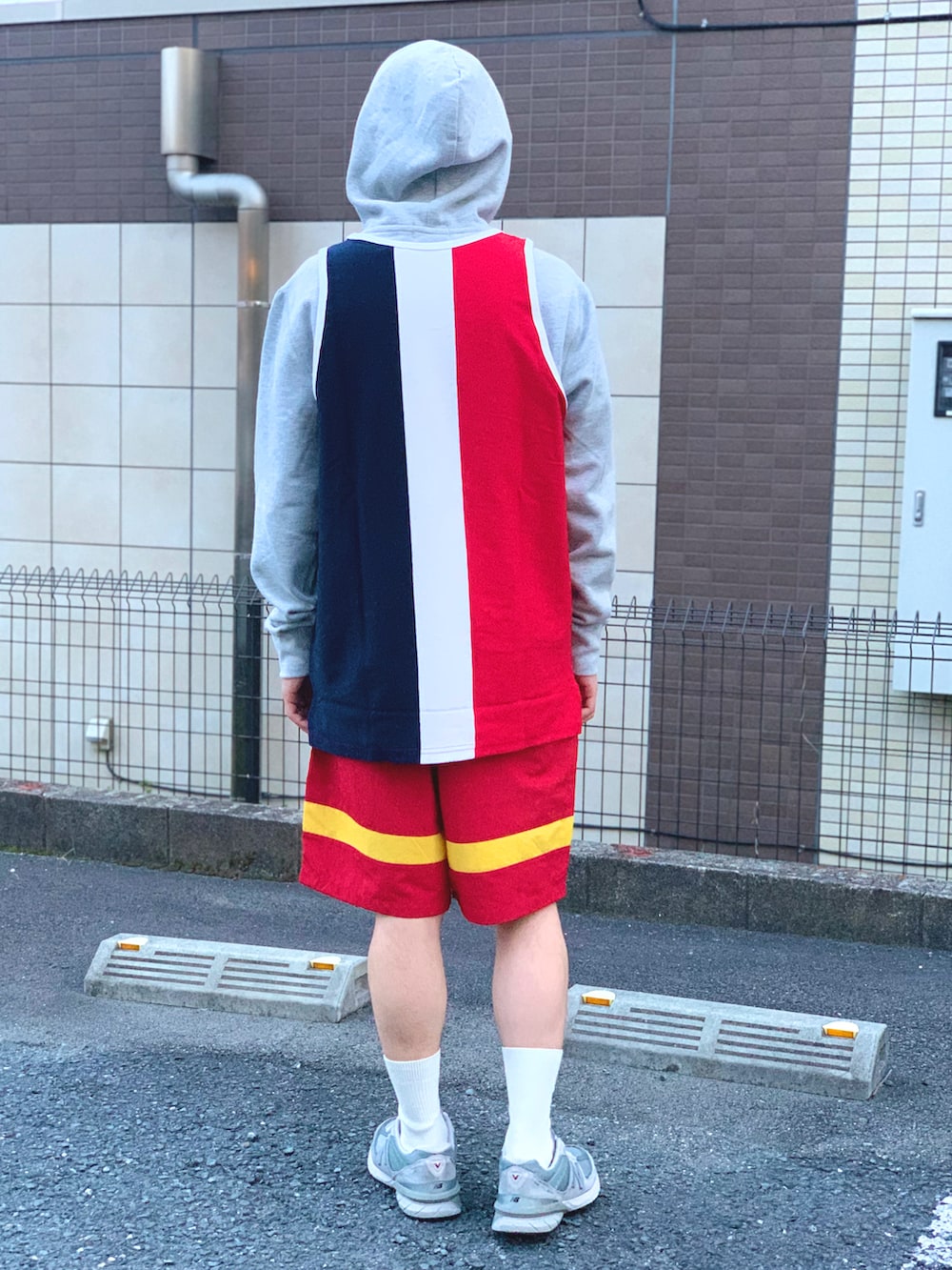 グレー系のパーカー、ホワイト系のタンクトップ、レッド系のその他パンツを着用したメンズの春コーディネートの3枚目の写真