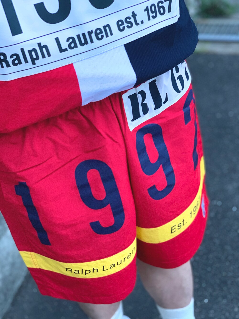 グレー系のパーカー、ホワイト系のタンクトップ、レッド系のその他パンツを着用したメンズの春コーディネートの2枚目の写真