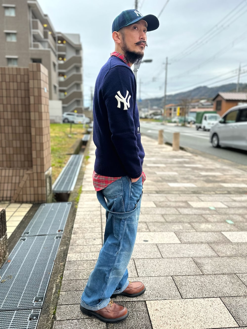 レッド系のシャツ/ブラウス、ブルー系のニット/セーター、ブルー系のサロペット/オーバーオールを着用したメンズの秋コーディネートの5枚目の写真