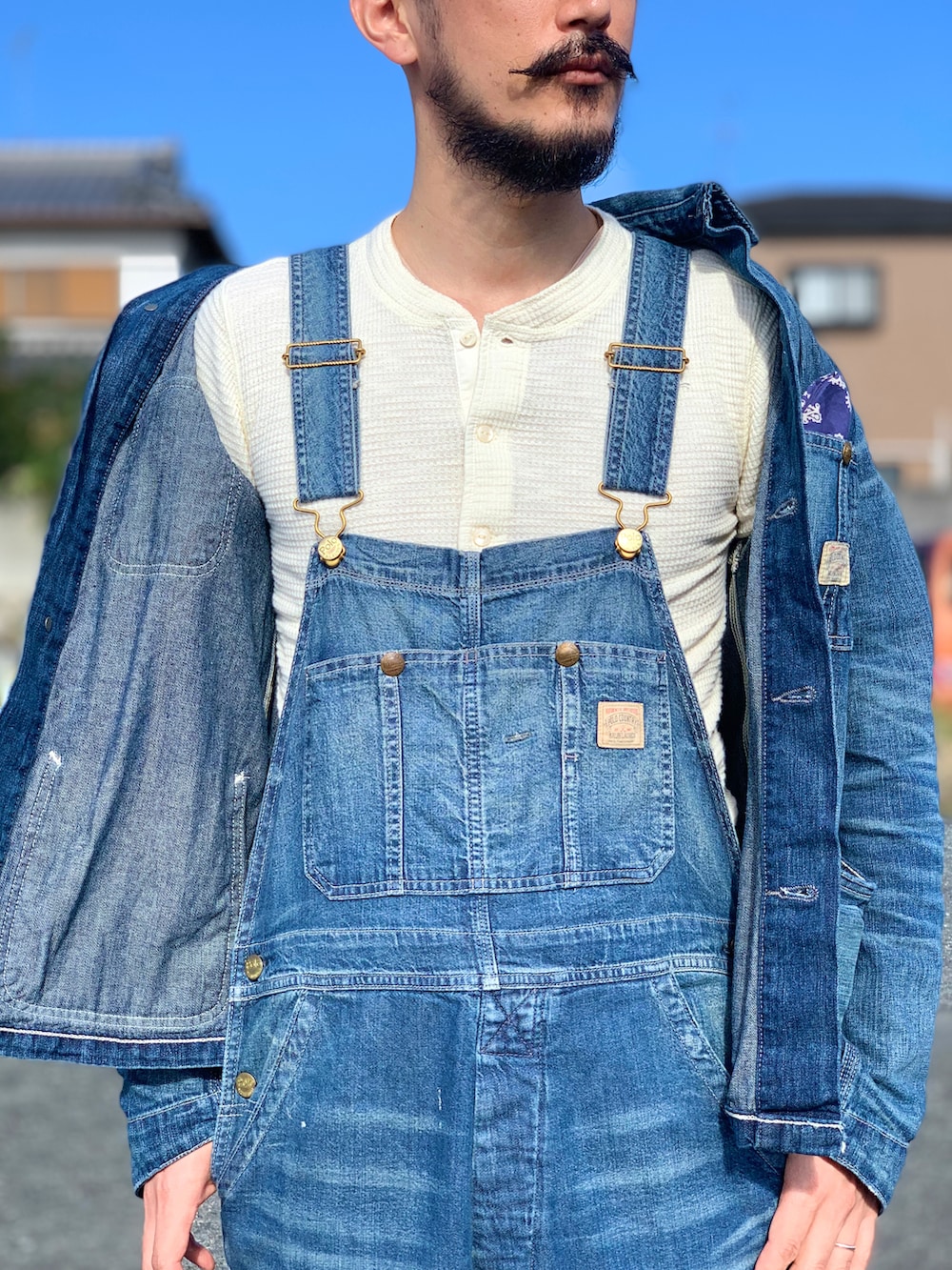 ホワイト系のTシャツ/カットソー、ブルー系のデニムジャケット、ブルー系のサロペット/オーバーオールを着用したメンズの秋コーディネートの4枚目の写真