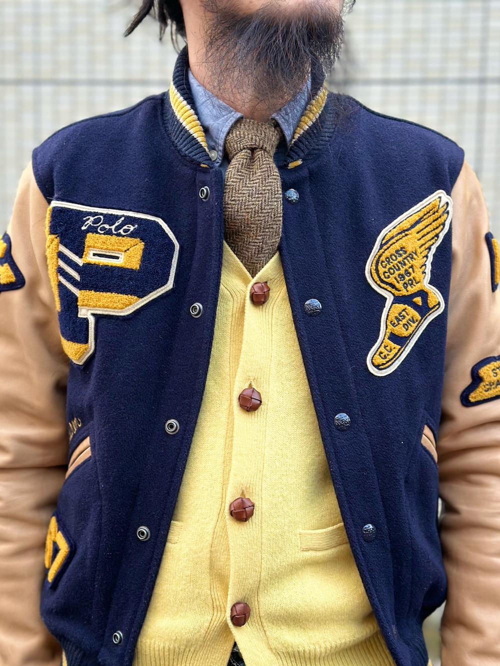 ブルー系のシャツ/ブラウス、ブラウン系のネクタイ、イエロー系のニット/セーターを着用したメンズの冬コーディネートの5枚目の写真