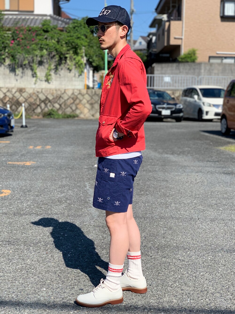 ホワイト系のTシャツ/カットソー、レッド系のブルゾン、ブルー系のパンツを着用したメンズの春コーディネートの5枚目の写真