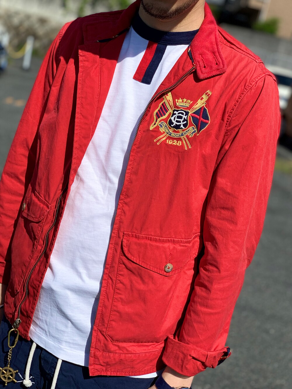 ホワイト系のTシャツ/カットソー、レッド系のブルゾン、ブルー系のパンツを着用したメンズの春コーディネートの3枚目の写真