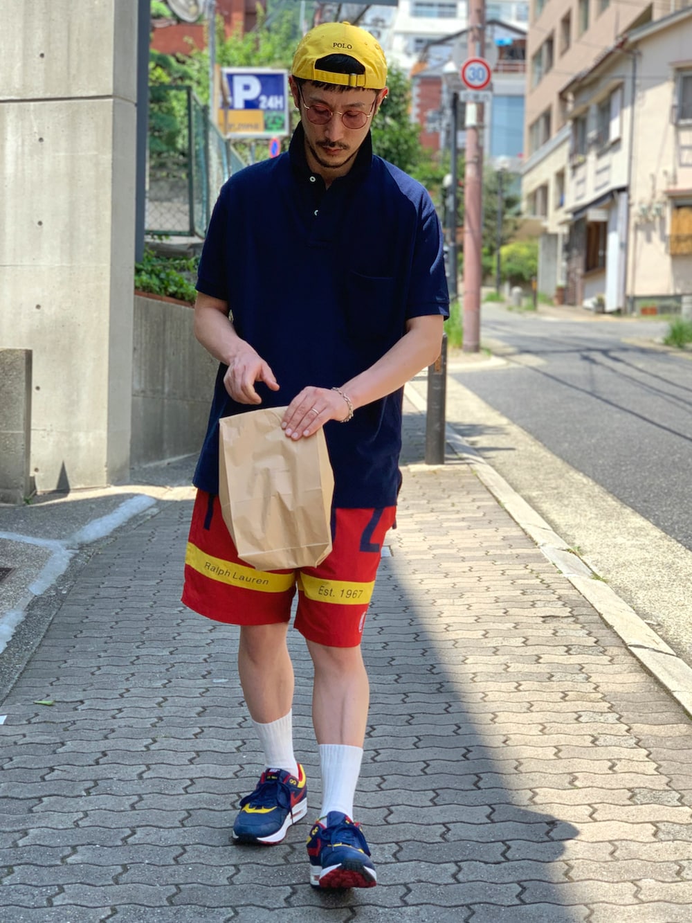 ブルー系のポロシャツ、レッド系のその他パンツ、その他のスニーカーを着用したメンズの夏コーディネートの2枚目の写真