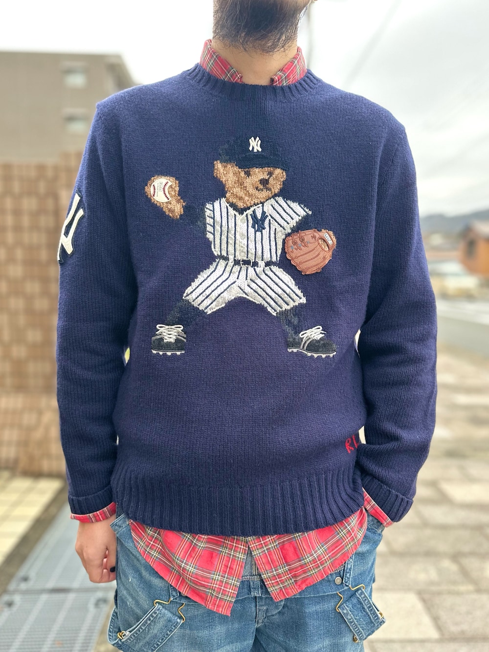 レッド系のシャツ/ブラウス、ブルー系のニット/セーター、ブルー系のサロペット/オーバーオールを着用したメンズの秋コーディネートの3枚目の写真