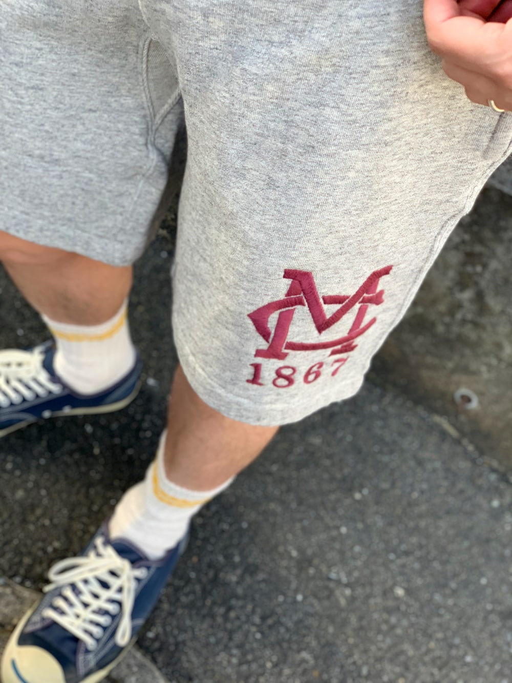 イエロー系のTシャツ/カットソー、ホワイト系のブルゾン、グレー系のパンツを着用したメンズの春コーディネートの3枚目の写真