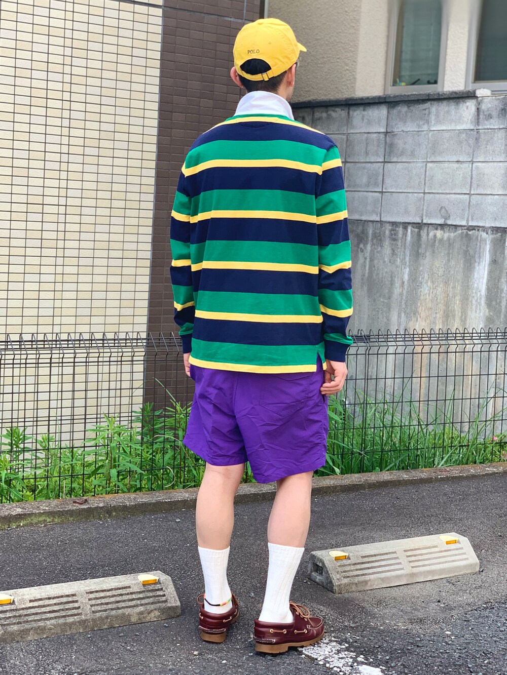 グリーン系のポロシャツ、パープル系のその他パンツ、レッド系のモカシン/デッキシューズを着用したメンズの春コーディネートの4枚目の写真