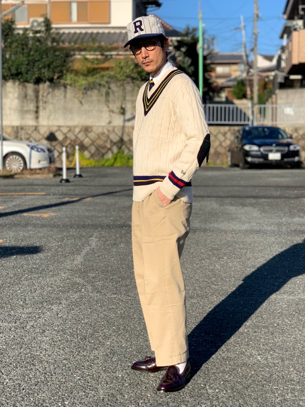 ブルー系のシャツ/ブラウス、イエロー系のネクタイ、ホワイト系のニット/セーターを着用したメンズの冬コーディネートの3枚目の写真