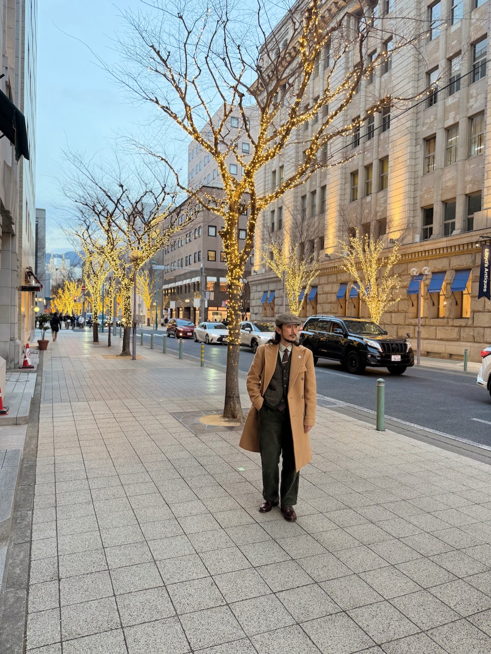 ベージュ系のシャツ/ブラウス、グリーン系のベスト、ブラウン系のチェスターコートを着用したメンズの冬コーディネートの4枚目の写真