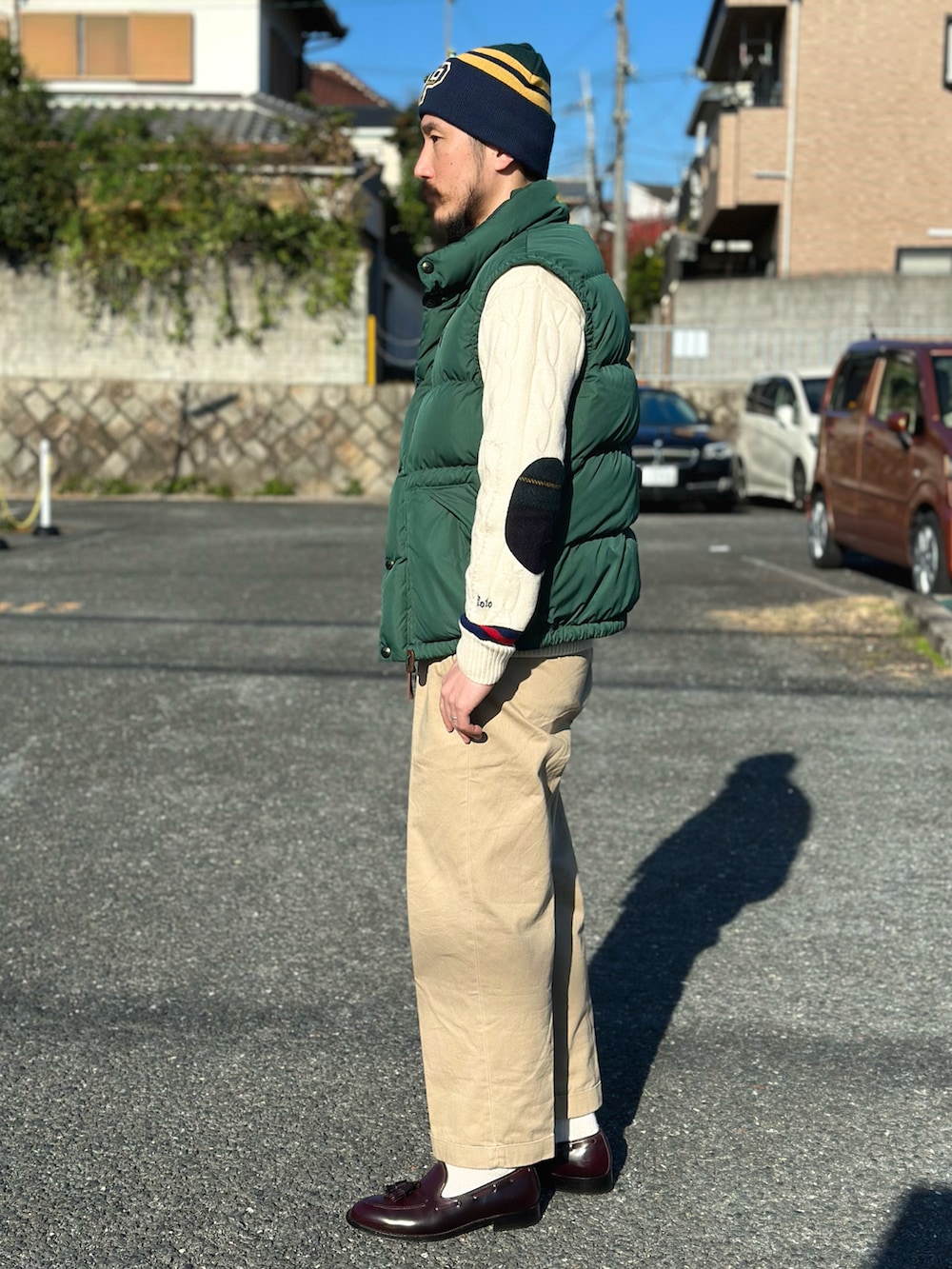 ホワイト系のシャツ/ブラウス、ホワイト系のニット/セーター、グリーン系のダウンベストを着用したメンズの秋コーディネートの4枚目の写真