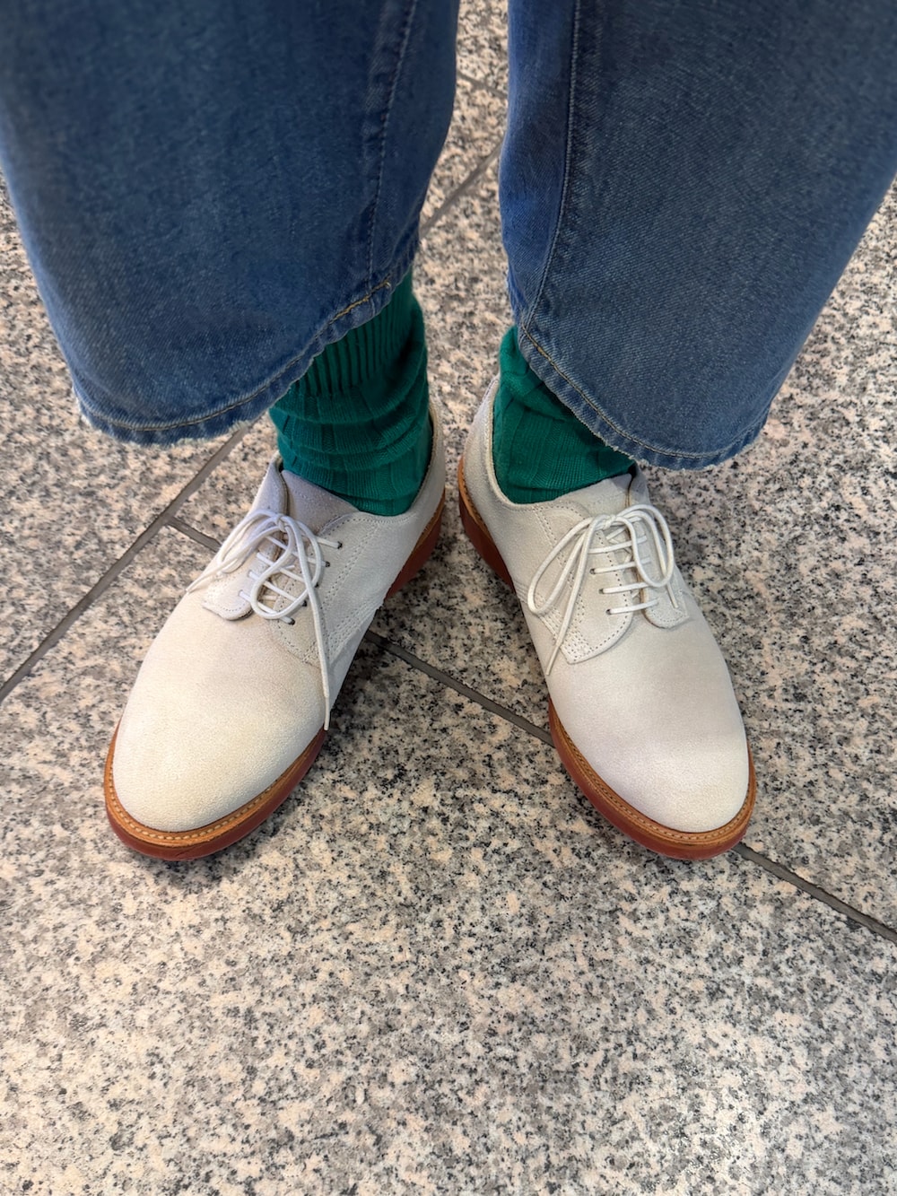 グリーン系のネクタイ、ブルー系のテーラードジャケット、ホワイト系のベストを着用したメンズの春コーディネートの5枚目の写真