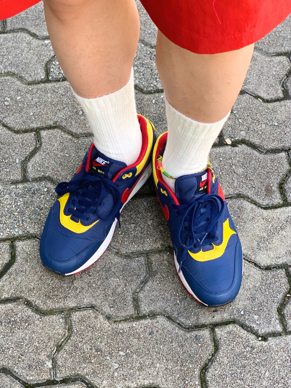 ブルー系のポロシャツ、レッド系のその他パンツ、その他のスニーカーを着用したメンズの夏コーディネートの5枚目の写真