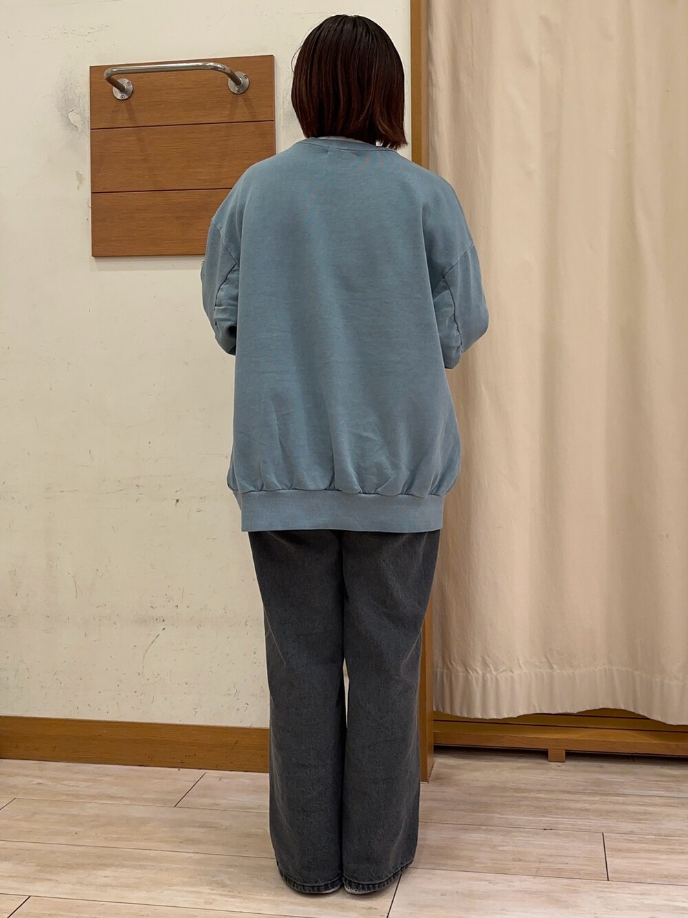 ブルー系のスウェット、ブラック系のデニムパンツを着用したレディースの秋コーディネートの3枚目の写真