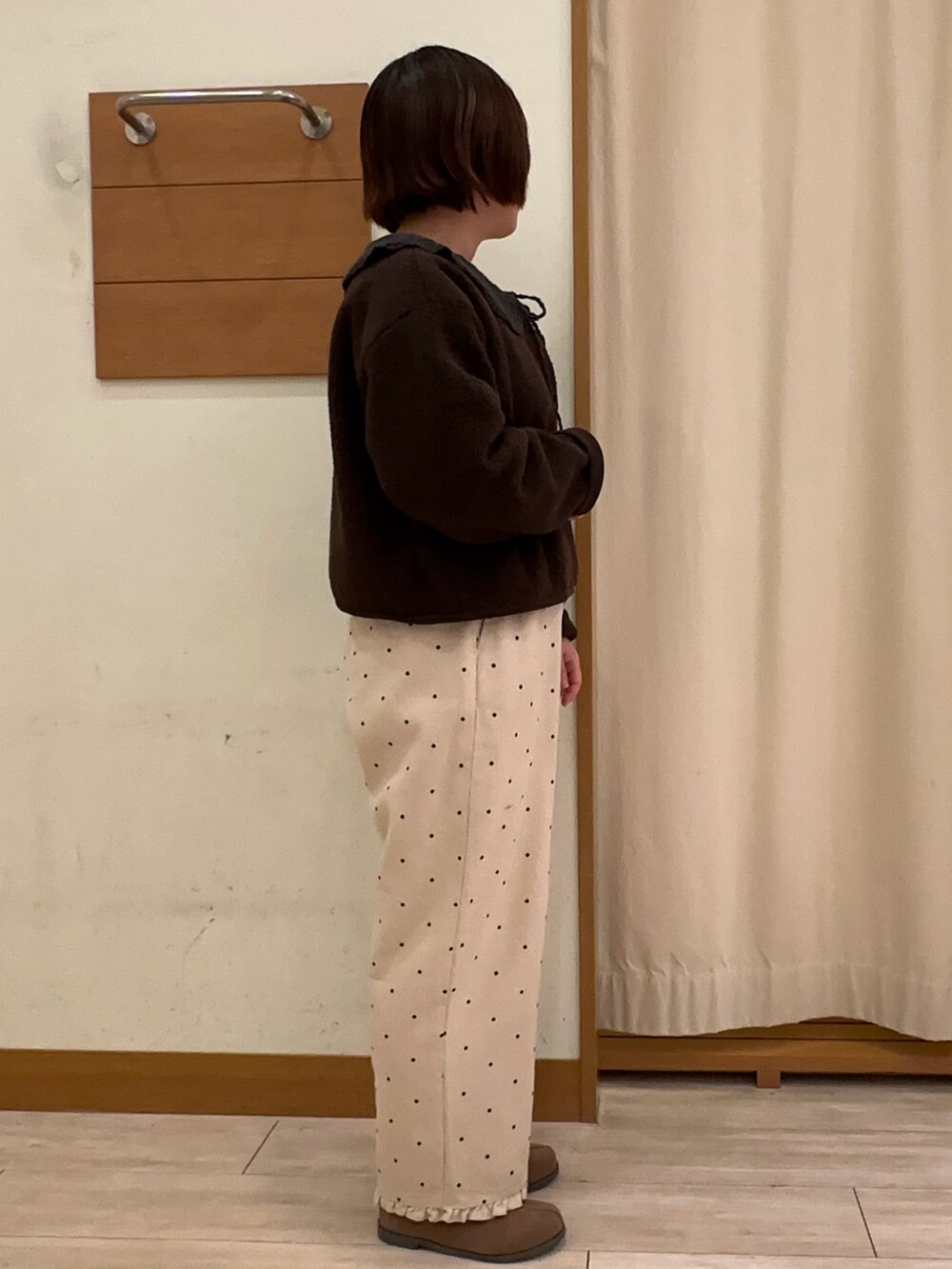 ブラック系のトップス、ブラウン系のブルゾン、ホワイト系のその他パンツを着用したレディースの秋コーディネートの2枚目の写真