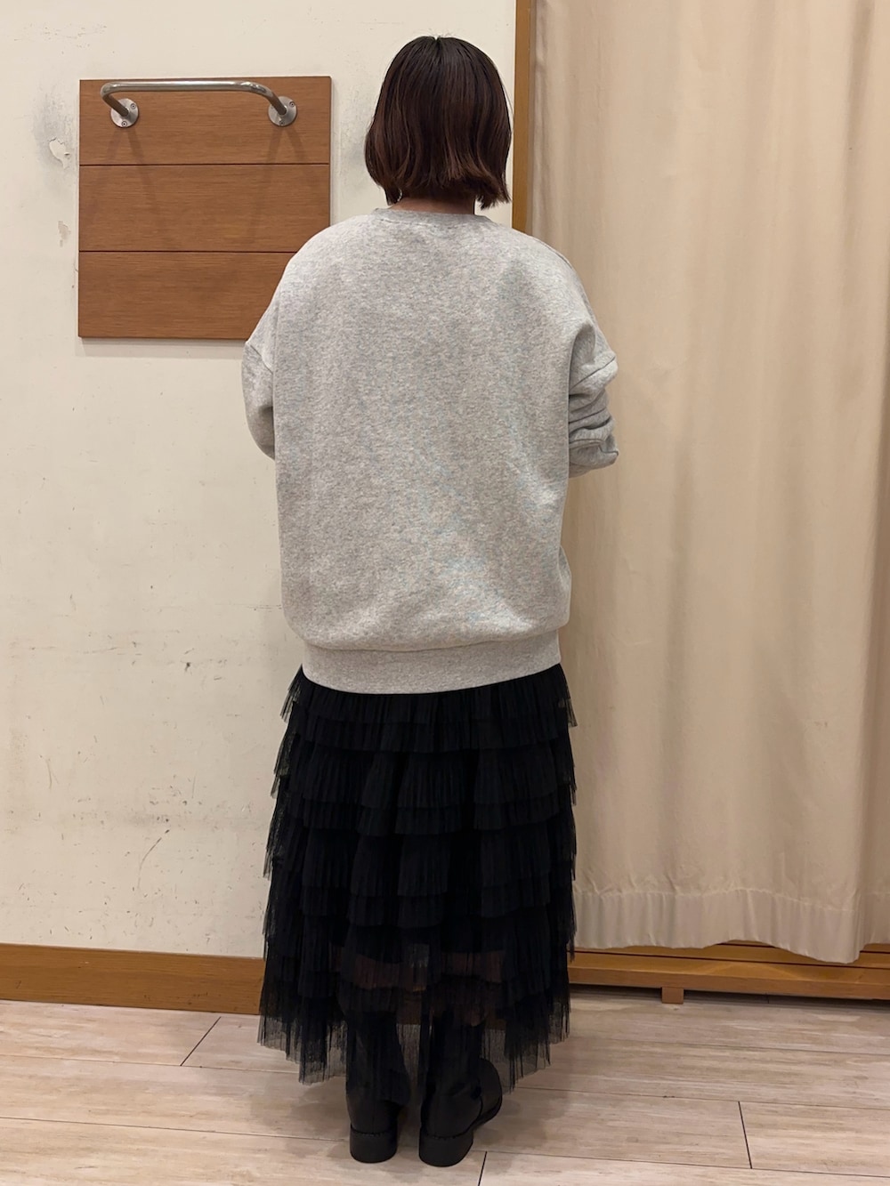 グレー系のスウェット、ブラック系のスカートを着用したレディースの秋コーディネートの3枚目の写真