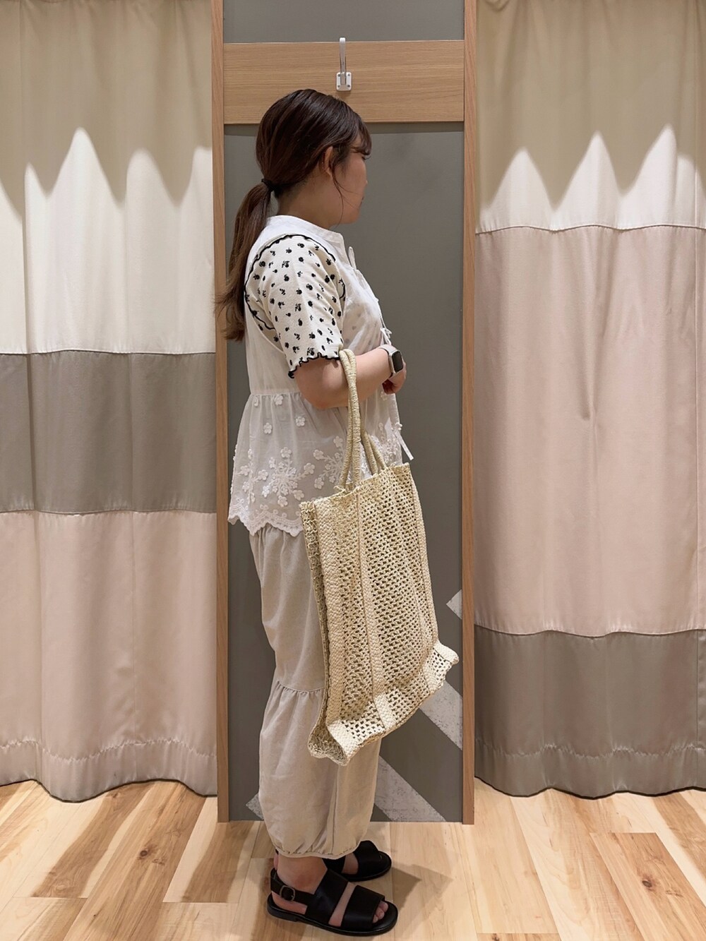 ホワイト系のベスト、ホワイト系のTシャツ/カットソー、ホワイト系のハンドバッグを着用したレディースの夏コーディネートの2枚目の写真