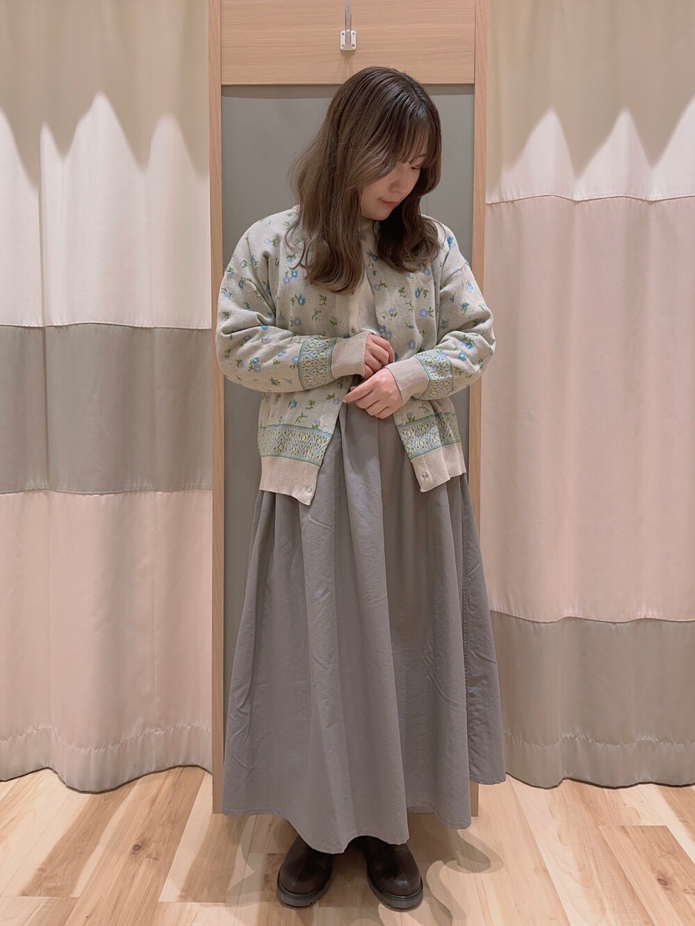 ブルー系のカーディガン/ボレロ、ホワイト系のシャツ/ブラウス、グレー系のスカートを着用したレディースの冬コーディネートの2枚目の写真