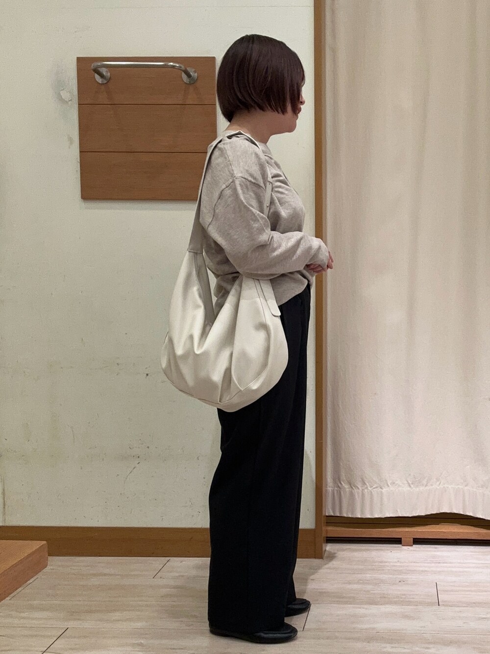 ベージュ系のニット/セーター、ブラック系のその他パンツ、ホワイト系のハンドバッグを着用したレディースの秋コーディネートの2枚目の写真