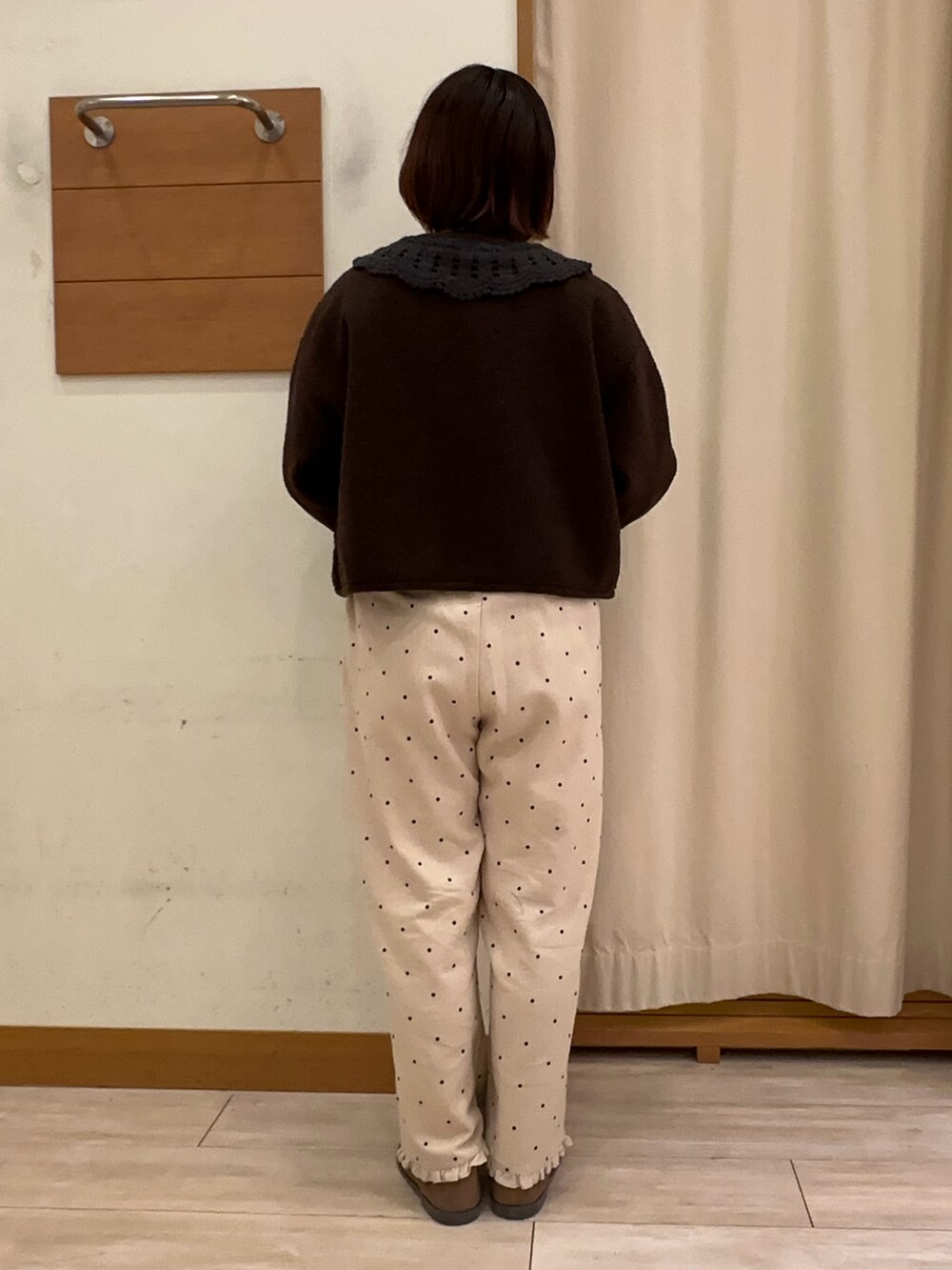 ブラック系のトップス、ブラウン系のブルゾン、ホワイト系のその他パンツを着用したレディースの秋コーディネートの3枚目の写真