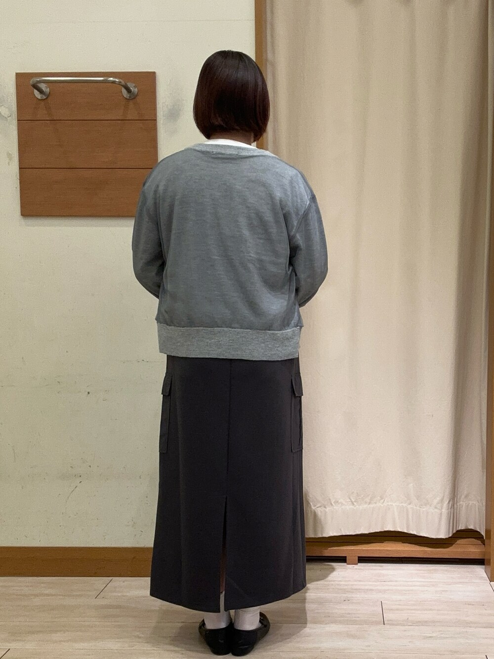 グレー系のカーディガン/ボレロ、ホワイト系のTシャツ/カットソー、グレー系のスカートを着用したレディースの秋コーディネートの3枚目の写真