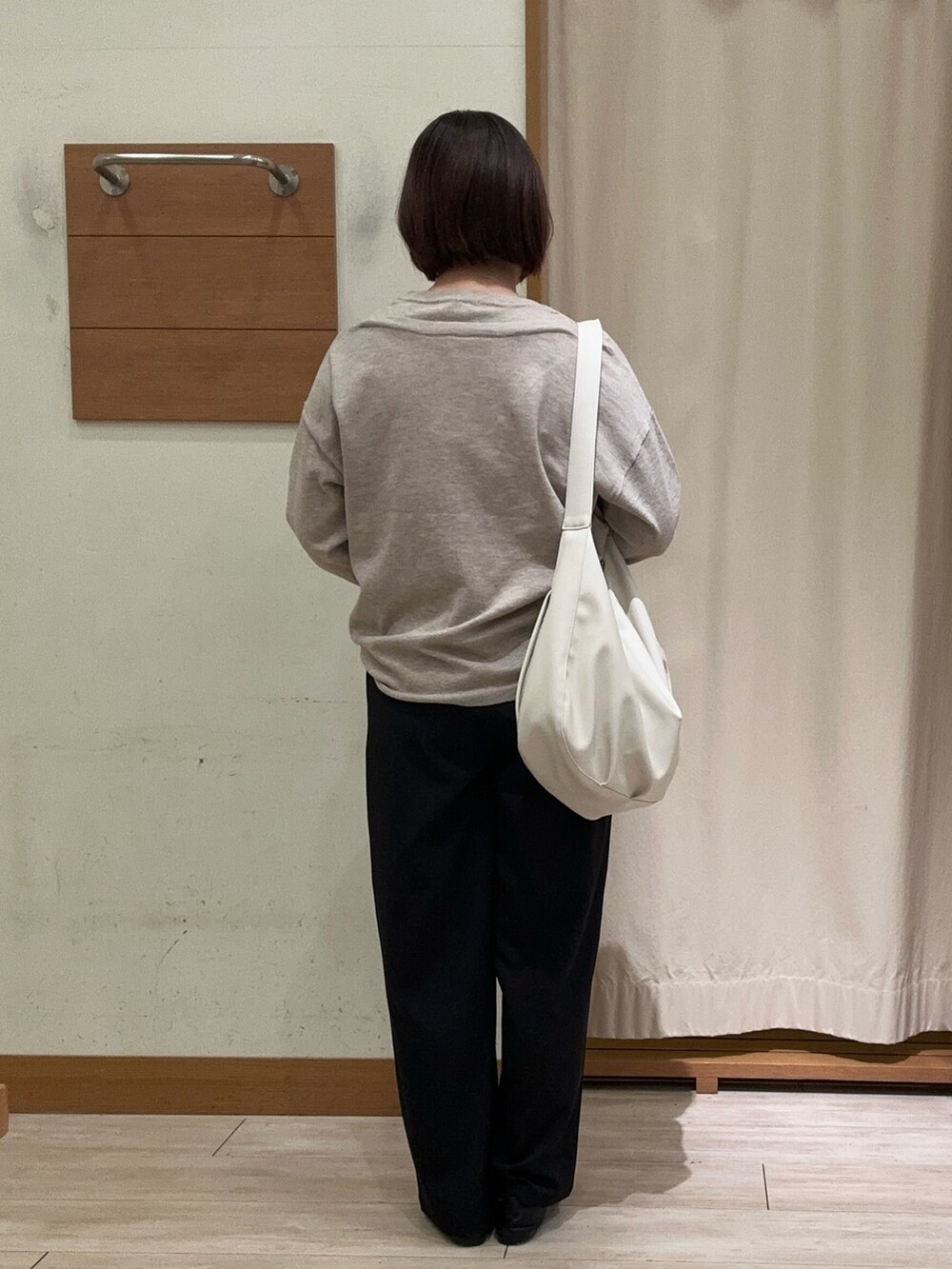 ベージュ系のニット/セーター、ブラック系のその他パンツ、ホワイト系のハンドバッグを着用したレディースの秋コーディネートの3枚目の写真