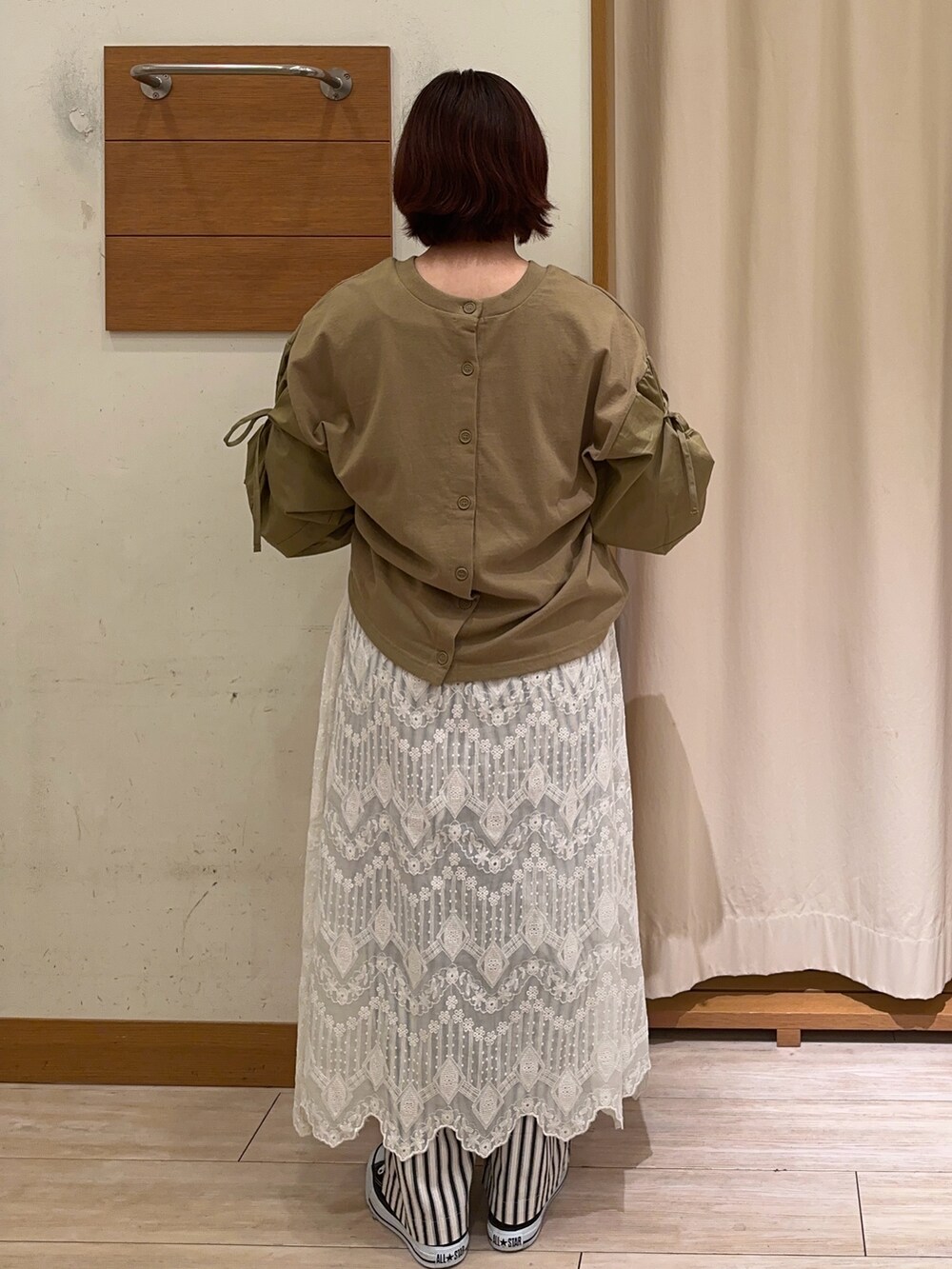 グリーン系のTシャツ/カットソー、ホワイト系のスカート、ホワイト系のパンツを着用したレディースの秋コーディネートの3枚目の写真