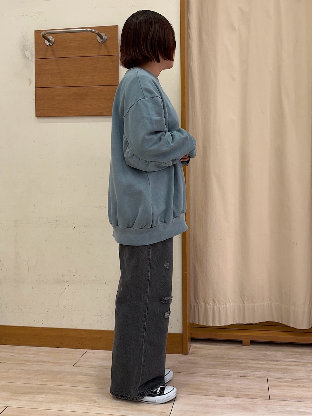 ブルー系のスウェット、ブラック系のデニムパンツを着用したレディースの秋コーディネートの2枚目の写真