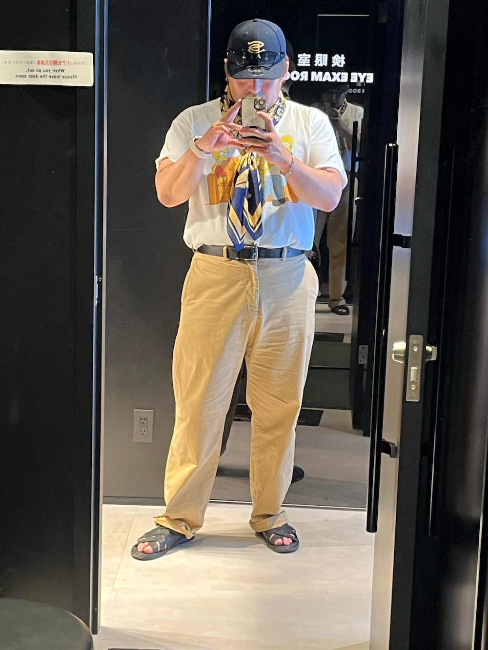 ホワイト系のTシャツ/カットソー、ブラウン系のチノパンツ、ブルー系のキャップを着用したメンズの夏コーディネートの2枚目の写真
